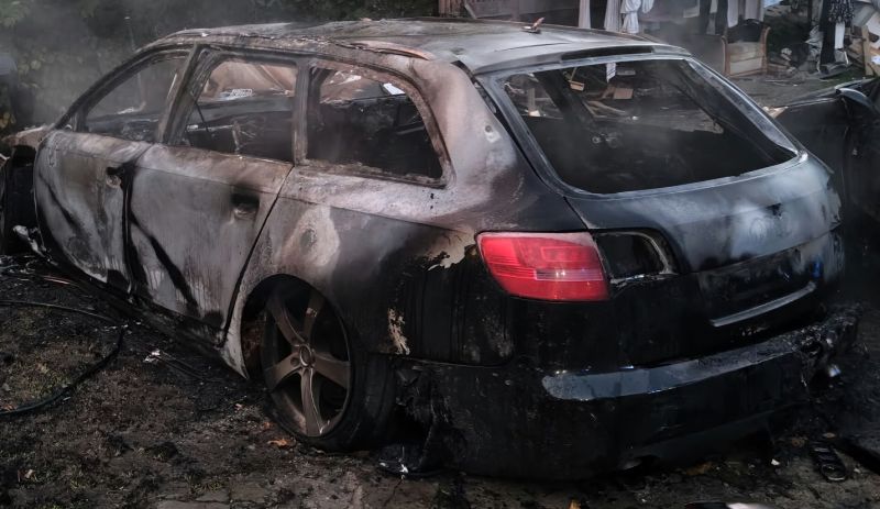 Pożar samochodu przy budynku mieszkalnym i policjantka ratująca mieszkańców